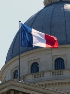 pexels-photo-9180728-9180728 The French flag waves on a flagpole beside the Pantheon dome in Paris, France.